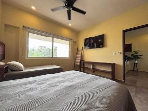 een slaapkamer met een bed en een plafondventilator bij Holiday apartment at La Diosa condos Isla Mujeres in Isla Mujeres +13 foto's