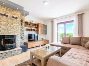 een woonkamer met een bank en een open haard bij Prima Natura, Imotski in Kutleše