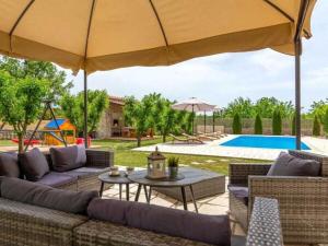 een patio met een bank, een parasol en een zwembad bij Prima Natura, Imotski in Kutleše