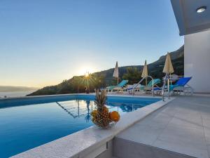 a bowl of fruit sitting on the edge of a swimming pool at Maslina with heated pool in Veliko Brdo
