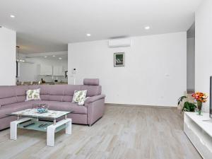 a living room with a purple couch and a table at Maslina with heated pool in Veliko Brdo