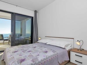 a bedroom with a bed and a balcony at Maslina with heated pool in Veliko Brdo +22 photos