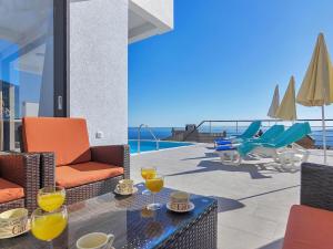 a patio with chairs and a table with wine glasses at Maslina with heated pool in Veliko Brdo