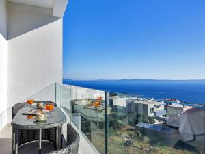 a table on a balcony with a view of the ocean at Maslina with heated pool in Veliko Brdo