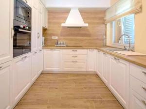 een keuken met witte kasten en een spoelbak bij Zara with heated hydromassage pool in Jasena Majići