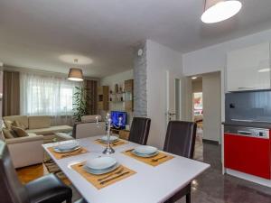 a kitchen and living room with a table and chairs at Villa Mia with pool in Aračići
