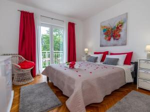 a bedroom with a large bed with red pillows at Villa Mia with pool in Aračići +38 photos
