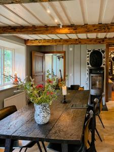 un comedor con una mesa de madera con flores. en Framed Structure With Annexes In Österlen, en Brösarp 31 fotos más