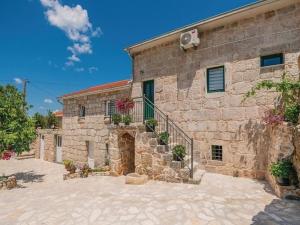 a stone building with a staircase in front of it at Buljanovi Dvori with private pool in Garci