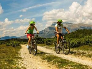 two people riding bikes down a dirt road at Buljanovi Dvori with private pool in Garci