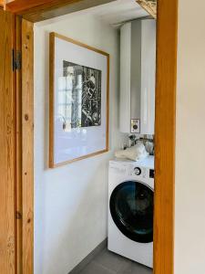 lavadero con lavadora y una foto en Framed Structure With Annexes In Österlen, en Brösarp