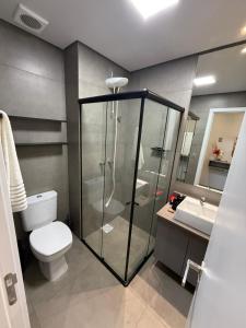 a bathroom with a shower and a toilet and a sink at Loft em Xangri-Lá com piscina aquecida in Xangri-lá