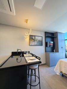 a kitchen with a black island in a room at Loft em Xangri-Lá com piscina aquecida in Xangri-lá