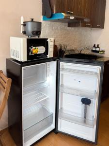 a kitchen with an open refrigerator and a microwave at Destiny Hotel - 1605 in Sampong