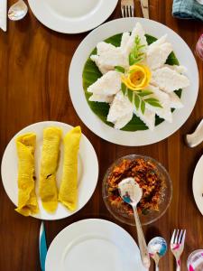 Una mesa de madera con platos de comida encima. en The Travellers Rest, en Katunayake