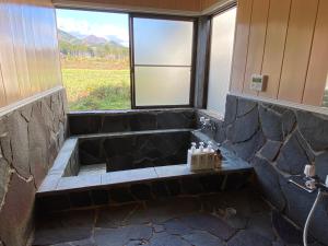 a bathroom with a stone tub with a window at 天然プラネタリウムcottage星空A棟 in Nasushiobara