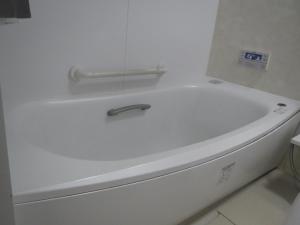 La salle de bains est pourvue d'une baignoire blanche. dans l'établissement 日田グリーンツーリズム花の木, à Ueda