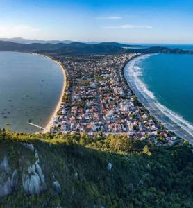 an aerial view of a beach and the ocean at Kitinet 06 aconchego, 350 meters from 4 Ilhas in Bombinhas