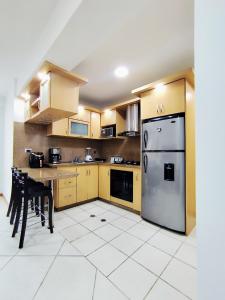 een keuken met gele kasten en een roestvrijstalen koelkast bij Hosting in Naguanagua in Naguanagua