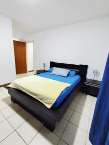 een slaapkamer met een groot bed met blauwe lakens bij Hosting in Naguanagua in Naguanagua +18 foto's