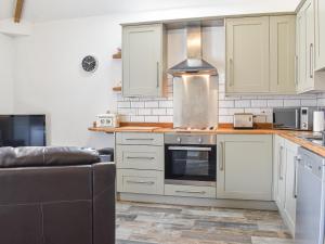 een keuken met witte kasten en een kookplaat oven bij The Dairy At Brook House Farm-Uk40631 in Church Minshull