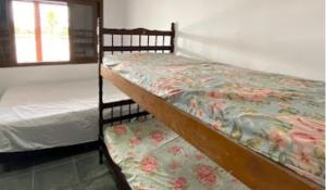 a bedroom with two bunk beds and a window at Casas em frente ao mar com piscina, churrasqueira in Pontal do Paraná