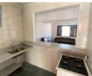 a kitchen with a sink and a stove top oven at Casas em frente ao mar com piscina, churrasqueira in Pontal do Paraná +16 photos