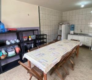 a kitchen with a table and chairs in a room at Casas em frente ao mar com piscina, churrasqueira in Pontal do Paraná