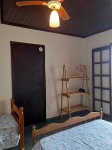 a bedroom with two beds and a ceiling fan at Casas em frente ao mar com piscina, churrasqueira in Pontal do Paraná