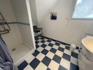 Un baño con una silla negra y un suelo ajedrezado en Maison calme pour 10 pers, proche plage, Port Navalo, animaux admis, wifi - FR-1-775-42, en Port-Navalo 18 fotos más