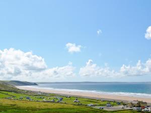 a beach with a bunch of cars parked on the grass at Pebble Cottage - Hw7447 in Broad Haven