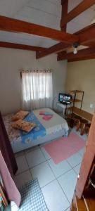 a bedroom with a bed and a tv in it at Kitinet 06 aconchego, 350 meters from 4 Ilhas in Bombinhas +13 photos