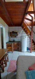 a kitchen with a table and a refrigerator at Kitinet 06 aconchego, 350 meters from 4 Ilhas in Bombinhas