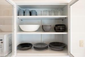 a white cabinet filled with bowls and plates at 天然プラネタリウムcottage星空E棟 in Anazawa +12 photos