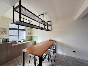 a dining room with a wooden table and a chandelier at 台東依三山民宿 尚武館 in Dawu