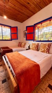 a bedroom with two beds and two windows at Hotel Hacienda Inglaterra in Sevilla