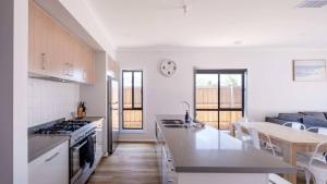 a kitchen and living room with a stove top oven at The Robinson in Connewarre