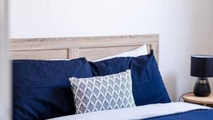 a bed with blue pillows and a wooden headboard at The Robinson in Connewarre +6 photos