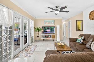 een woonkamer met een bank en een tv bij The Flamingo*4bed*pool*jacuzzi*foosball in Valrico