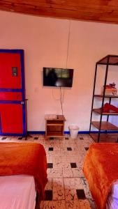 a room with two beds and a flat screen tv at Hotel Hacienda Inglaterra in Sevilla