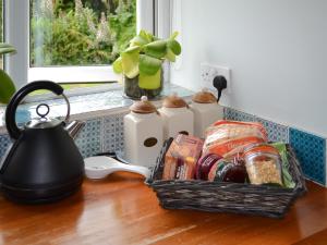 Una canasta de comida sobre una mesa con una tetera. en Homestead, en Long Sutton