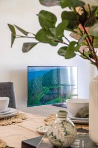 a table with a picture and a vase on it at Bright & Cozy 2BR Duplex near Logan Central Comforts in Marsden