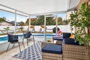 een patio met blauwe stoelen en een zwembad bij The Flamingo*4bed*pool*jacuzzi*foosball in Valrico