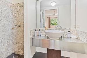 a bathroom with a sink and a shower at Palm Cove Studio Pools Spa Bar in Palm Beach
