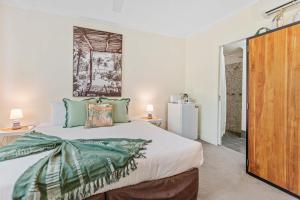 a bedroom with a bed and a refrigerator at Palm Cove Studio Pools Spa Bar in Palm Beach