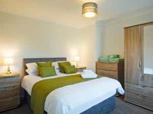 a bedroom with a large bed with green pillows at Headlands House - Uk6739 in Lydstep