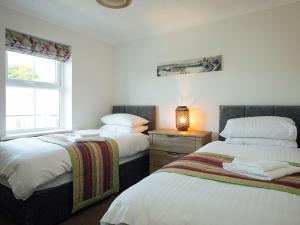 a bedroom with two beds and a window at Headlands House - Uk6739 in Lydstep