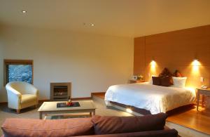 a large bedroom with a bed and a couch at Wilderness Lodge Arthurs Pass in Arthur's Pass +12 photos
