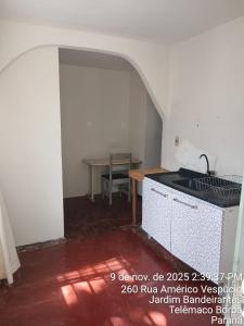 een keuken met een wastafel en een tafel in een kamer bij Kitnet na Band in Telêmaco Borba