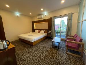 a hotel room with a bed and a chair at Universal Bliss in Pokhara